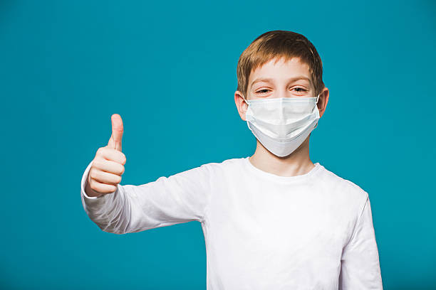 istock Boy showing thumb up in protection mask 464546208