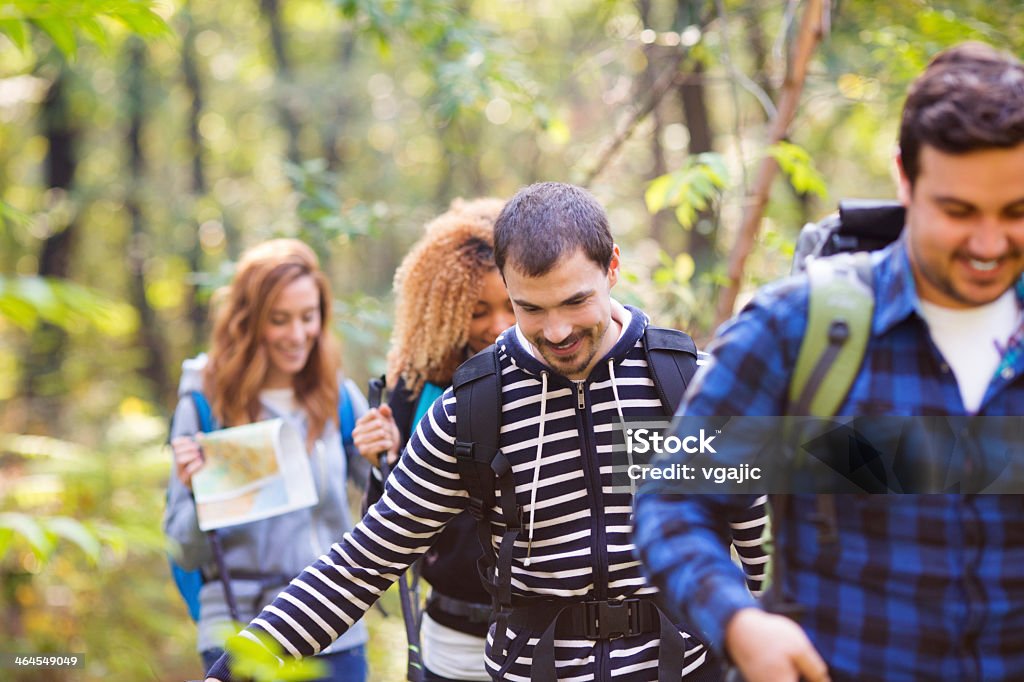 Friends hiking in a forest. Cheerful friends hiking in forest together. Active Lifestyle Stock Photo