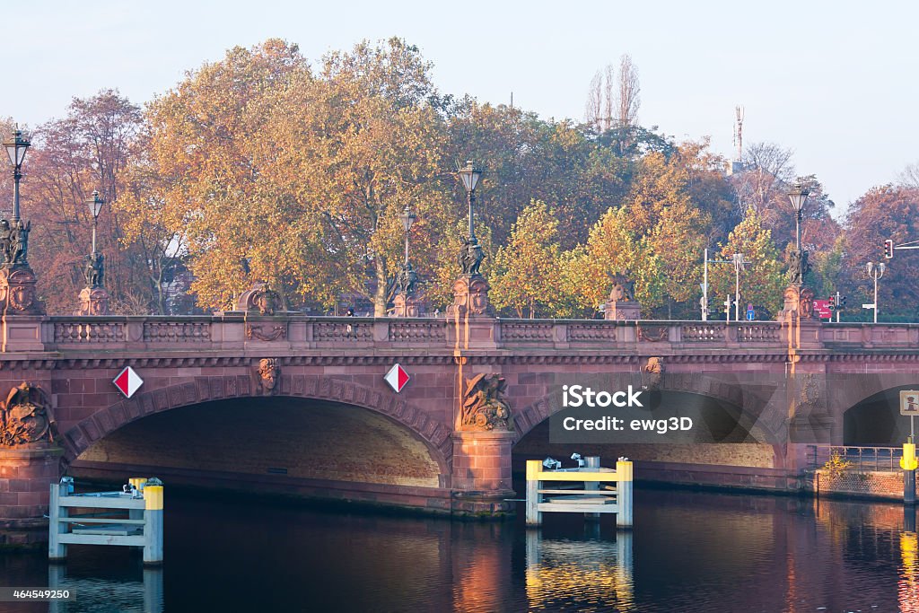 Moltke bridge, Berlin Autumn morning with Moltke bridge over the Spree river in Berlin, Germany. The bridge has three crossed arches spanning the Spree made from red sandstone decorated with statues and street lanterns. 2015 Stock Photo