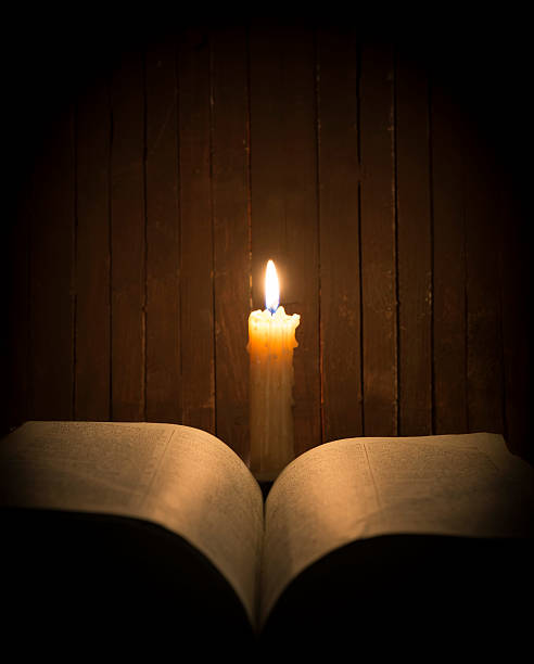 istock Candle with book in the darkness 464549366