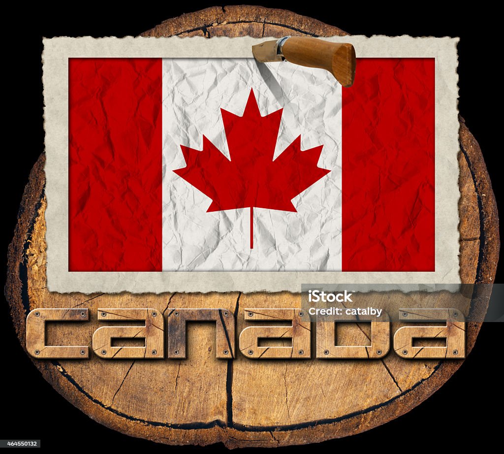 Canadian Flag on Section of Tree Trunk Flag of Canada in a old photo frame with wooden text canada on a section of tree trunk isolated on black background 2015 Stock Photo