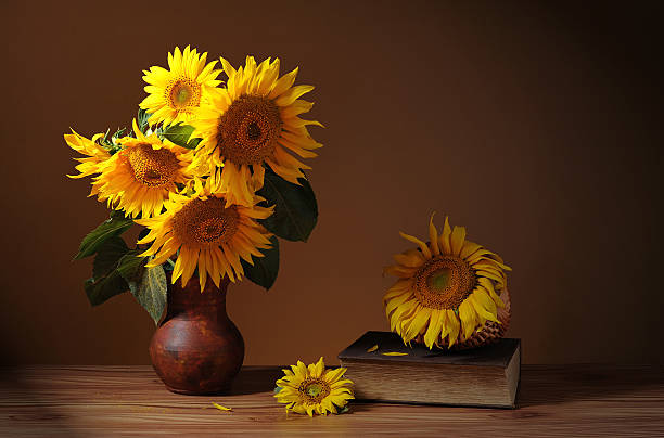 istock Sunflower in a ceramic vase, books and wicker basket 464550484