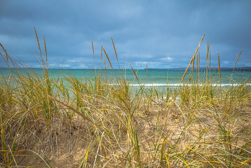 The blue waters of the Atlantic with sand dune and dune grass in the foreground.