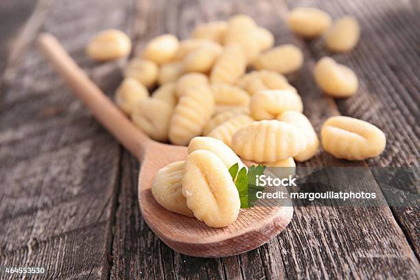 Raw Gnocchi On A Spoon On A Wooden Table Stock Photo - Download Image Now - Gnocchi, 2015, Backgrounds