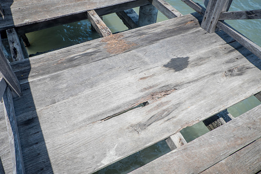 Unsafe boardwalk over the sea with missing parts