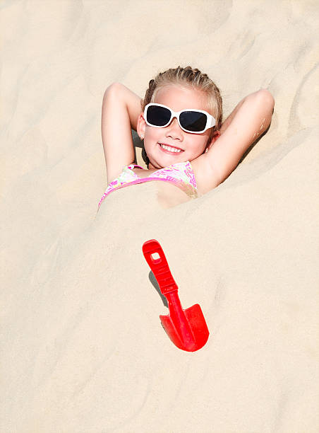 istock Happy cute little girl lying in sand 464560238