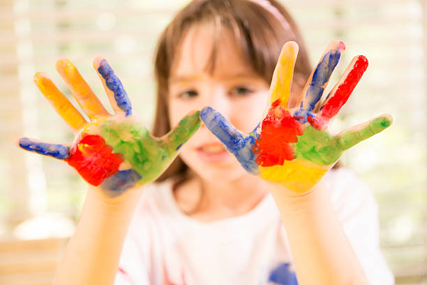 istock Art: Little girl finger painting. Multi-colored hands. School. 464561643