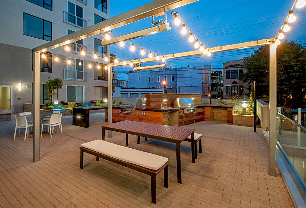Outdoor patio with barbecue and lights, early evening.