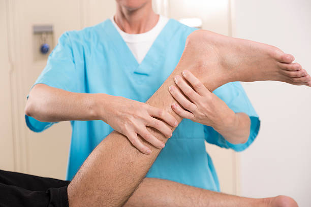 医療: 物理療法士、男性アスリートのロッカールームがございます。 傷害ます。 - pain physical injury human leg human muscle ストックフォトと画像