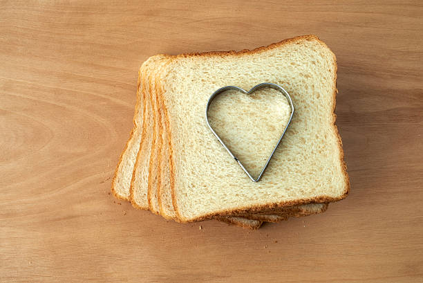 istock Slice of bread with cut out heart shape 464570515