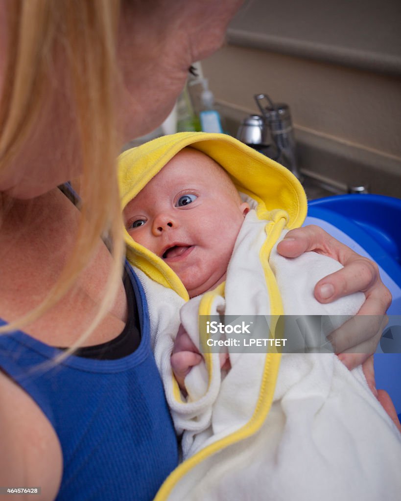 Baby Bath Baby boy wrapped in a towel after a bath. 2015 Stock Photo