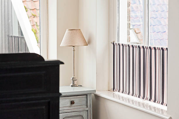 istock Lamp on white bedside table in bright hotel room. 464584521