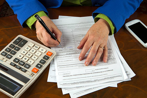 istock Woman fills tax return 464586211