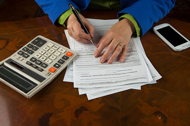 istock Woman fills tax return 464586213