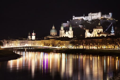 View of the old city of Salzburg, Austria, from the river Salzach by night