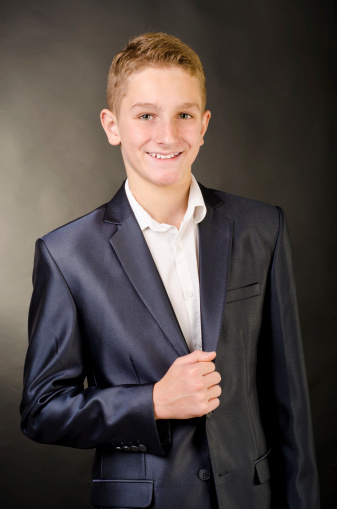 teenage boy in suit on a black background