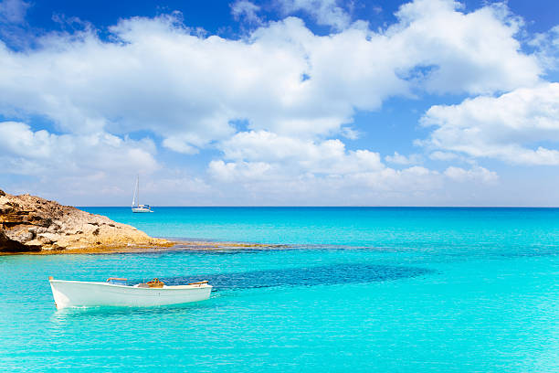 Es Calo de San Agusti with boat in Formentera Es Calo de San Agusti with boat in Formentera island turquoise mediterranean formentera island stock pictures, royalty-free photos & images