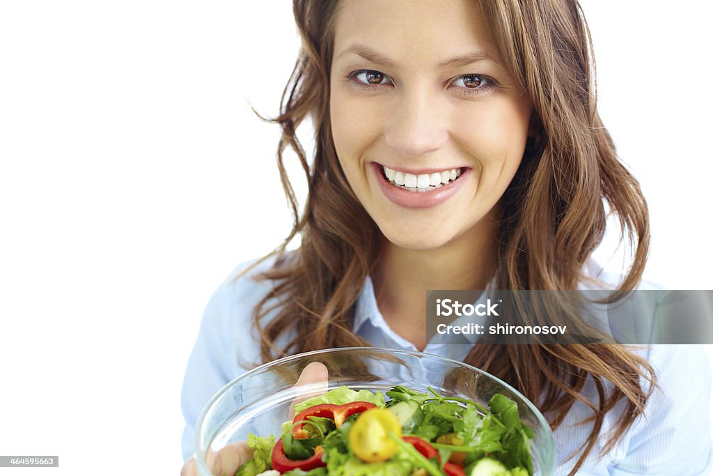 Female with salad Close-up of pretty girl holding fresh vegetable salad in glass bowl and looking at camera Adult Stock Photo