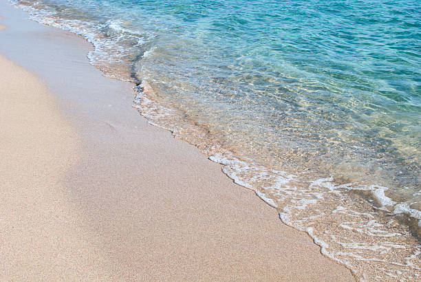 Wave washing over sea shore stock photo