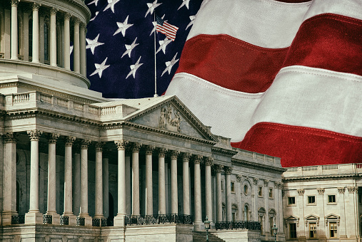 The United States Capitol Building in Washington DC with a U.S.A. flag in the background. A grunge effect has been applied.