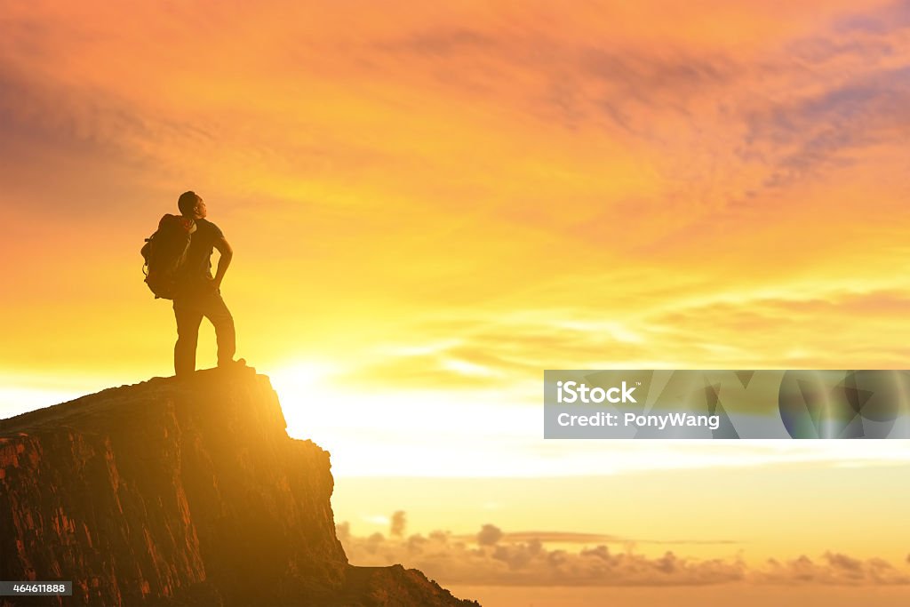 Success man on the mountain Silhouette of a Success man mountain climber stand on top of mountain and look sunshine 2015 Stock Photo