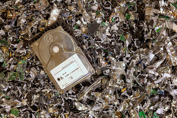 Crushed hard drives Hard drive resting on a pile of shredded hard drives. hard drive stock pictures, royalty-free photos & images