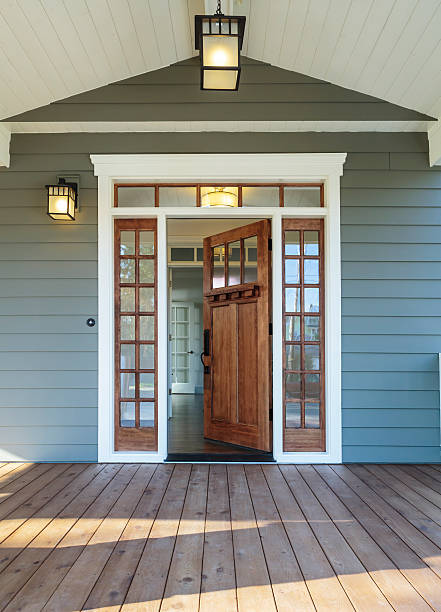 Front porch of blue-gray house with open front door stock photo