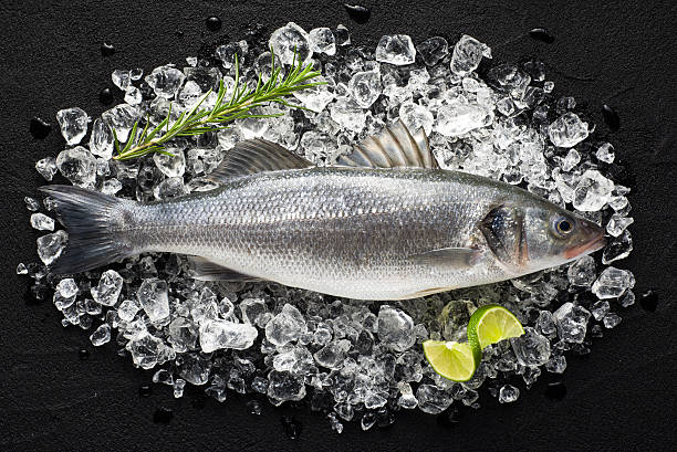 frischer fisch auf eis auf einem schwarzen stein tisch - black bass stock-fotos und bilder