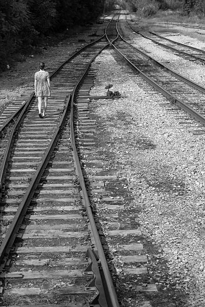 istock Girl walks alone on railroad tracks, black and white 464614144