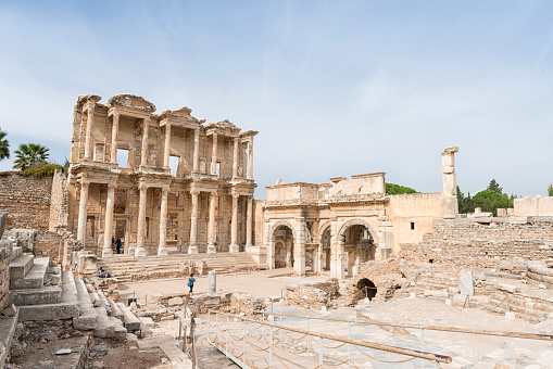 Selcuk, Turkey - October 17, 2014: The famous Celsus Library in Ephesus ancient city with its visitors. It's a sunny day with plenty of visitors walking around the Celsus Library. Ephesus is one of the major attractions in western Turkey. The Celsus library is an international landmark.