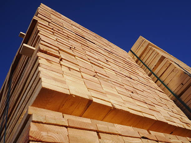 istock Stacks of planks against the deep blue sky 464622995