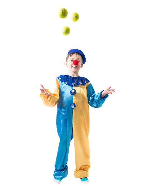 istock Little boy in clown suit juggling three balls 464623584
