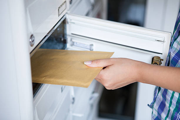 donna di mano tirando avvolgere dalla cassetta postale - postal worker delivering mail post office foto e immagini stock