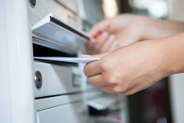 istock Woman putting letter in mailbox 464628879