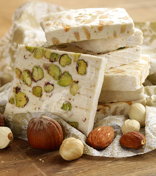 istock white nougat with different nuts on a wooden table 464630287