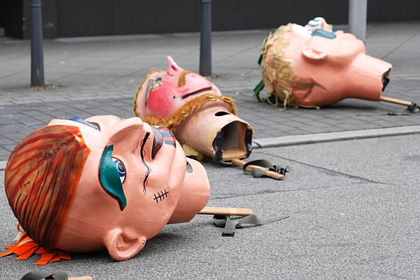 Mannheim, Germany - February 15, 2015: Fastnachtsumzug - carnival parade - traditional public event in the streets of Mannheim. Three oversized masks on street ready to be picked up.