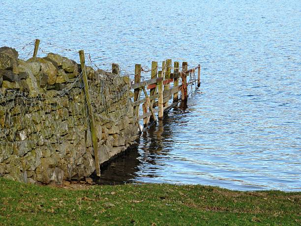 istock an old stone wall extending in to a lake 464638746