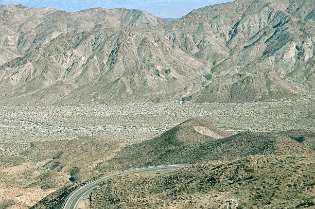 istock Road curves below mountain pass in southern California 464638986