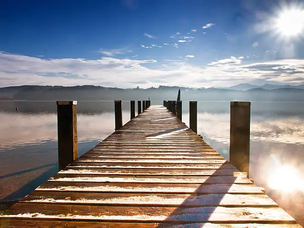 wooden jetty (189) at a little lake in upper bavaria with mountains in background