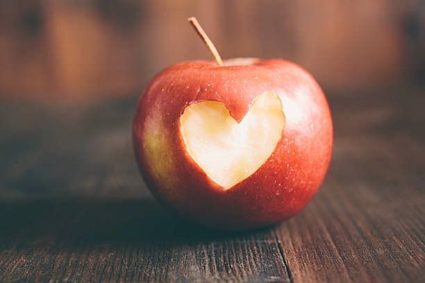 Apple with a heart cut into it stock photo