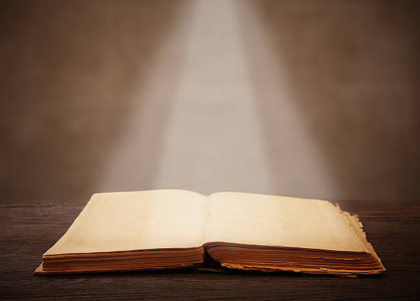 istock old open book  light beam illuminates the page 464642608