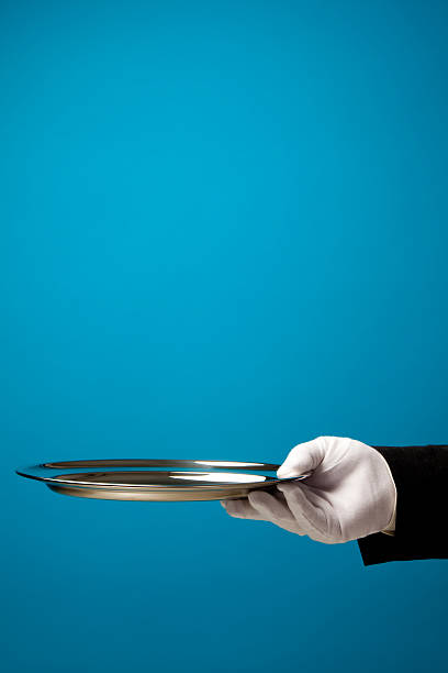 istock hand in white glove holding empty serving tray 464643460
