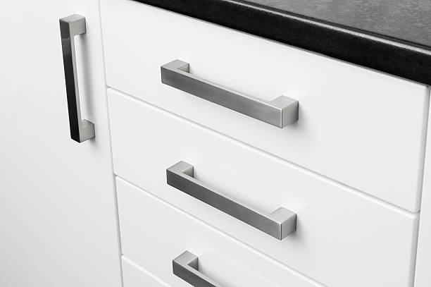 Kitchen storage unit handles Close-up metal handles on kitchen cupboard units. handle stock pictures, royalty-free photos & images