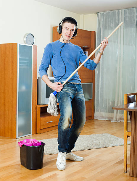istock Happy man washing  floor with mop in home 464645794