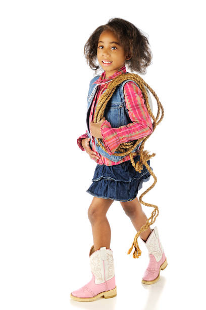 Little Roping Cowgirl Full-length image of an elementary African American cowgirl carrying a rope. On a white background. checkered cowboy boots stock pictures, royalty-free photos & images