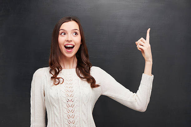 istock Funny cheerful woman pointing at chalkboard 464650034