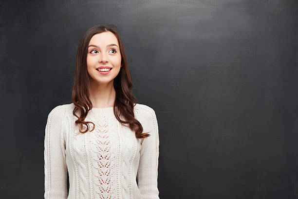 istock Smiling woman on chalkboard background 464650036