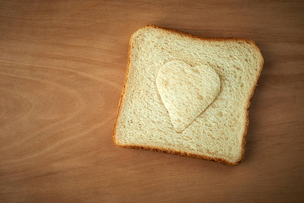 istock Slice of bread with cut out heart shape 464650859