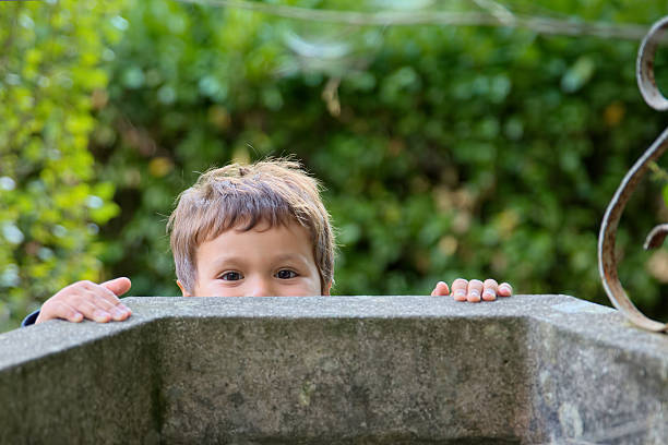 The child looks into the black hole of the cave. The concept of learning the unknown. Childish curiosity.