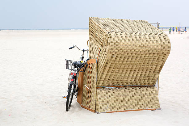 Lonely Beach chair with bike Lonely Beach chair with bike at the beach of St.Peter Ording, Germany hooded beach chair stock pictures, royalty-free photos & images